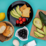 Top View Fresh Avocados Wood Kitchen Board With Avocado Slices Tomatoes Black Plate With Bucket Breads Blue